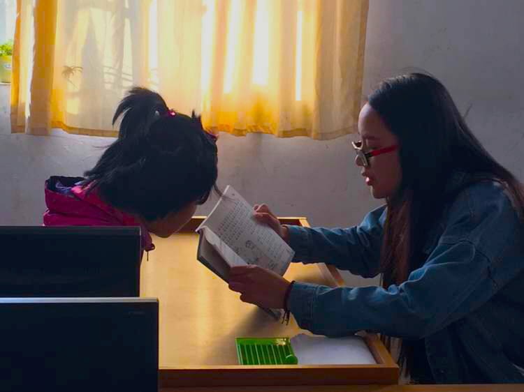 志愿者为视障孩子温习功课